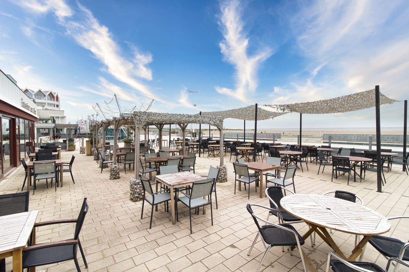 La terraza de Aux Aïeux en el paseo marítimo de Dunkerque, sus velas de sombra frente al mar