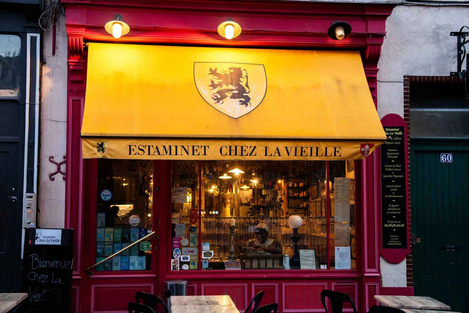 La fachada roja de Chez la Vieille, rue de Gand, con su toldo amarillo con el león de Flandes y su escaparate iluminado.